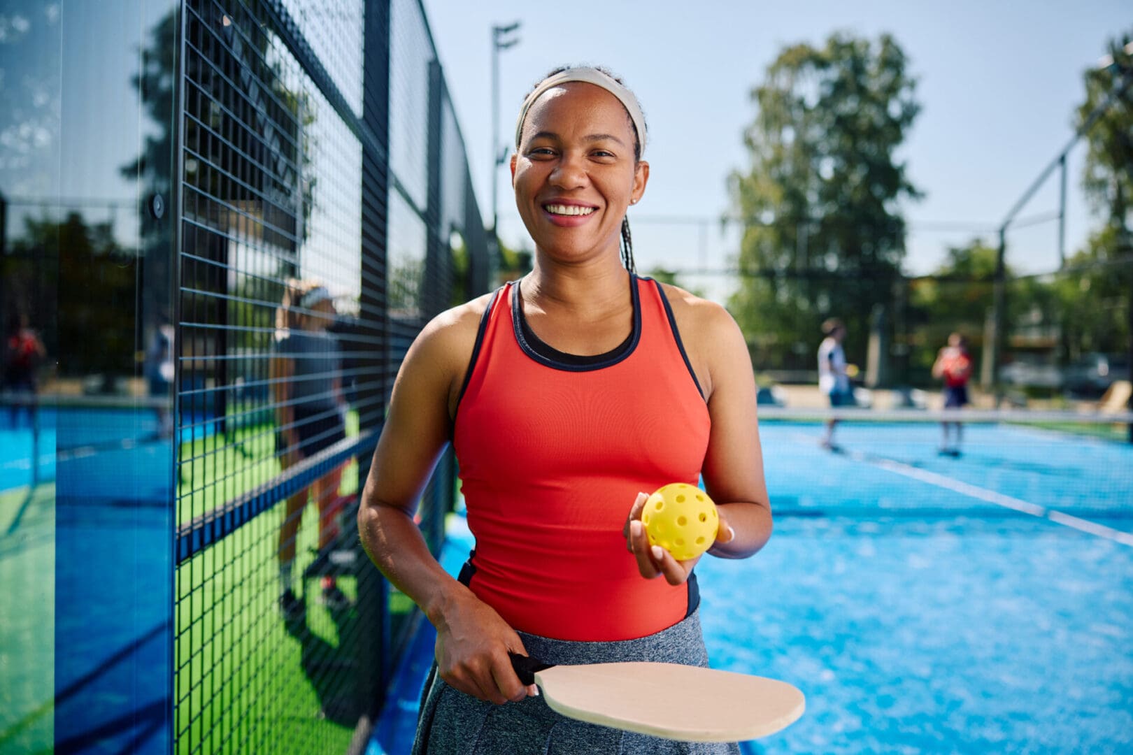 Woman playing pickleball on outdoor court.